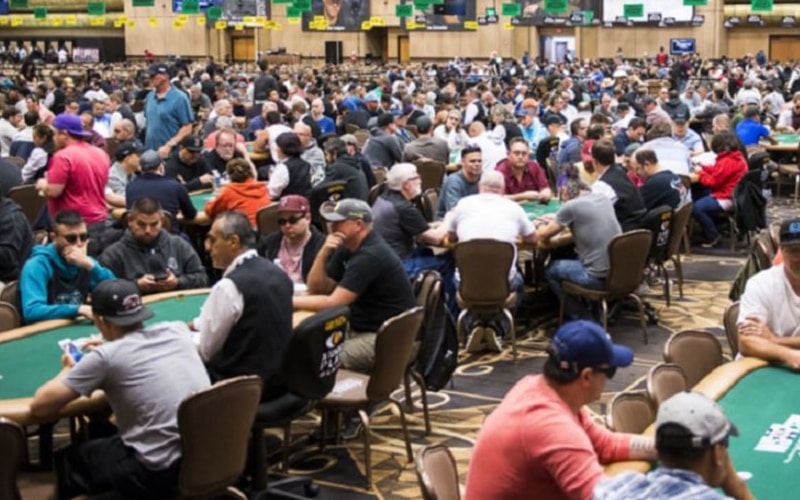 Sala gremita da persone che si divertono a giocare ad un semplice Gioco chiamato poker